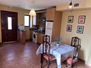 een keuken met een tafel en stoelen en een keuken met een koelkast bij La Casina Del Rio in Argovejo