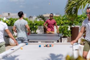 a group of men standing around a pool table at The Reef 28 - Adults Only - All Suites - Optional Gourmet All Inclusive in Playa del Carmen