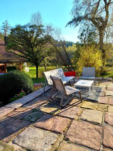 two chairs and a table on a stone patio at La petite ferme in La Chapelle +13 photos