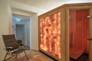 a room with a chair and a wall with a bed at Turmhotel zum Erasmus in Kelheim