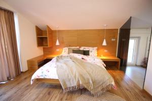 a bedroom with a bed with a wooden head board at Apartments ALPA VITA in Kobarid