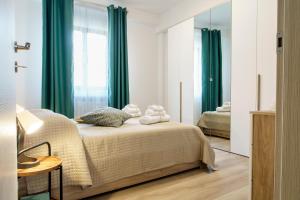 a bedroom with a bed with green curtains and a mirror at Itaca in Lido di Fermo