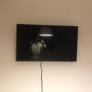 uma televisão com um homem a tirar uma fotografia numa parede em Capbreton hossegor chambre climatisée espace privé em Bénesse-Maremne