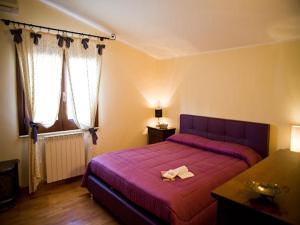 1 Schlafzimmer mit einem lila Bett und 2 Fenstern in der Unterkunft Villa Amanda in Mazara del Vallo