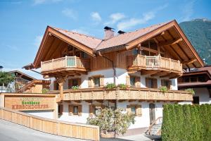 uma grande casa de madeira com varandas de madeira em Appartement Landhaus KERSCHDORFER em Kaltenbach