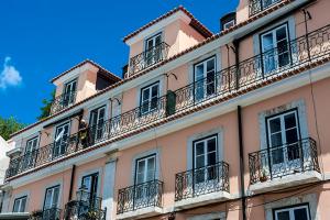 a tall pink building with balconies and windows at Portas do Teatro Apartments 2 in Lisbon