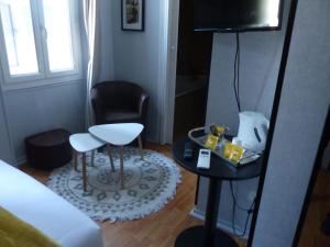 a small room with a bed and a chair and a table at Hotel Le Rochegude in Albi