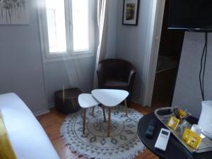 a living room with a chair and a stool at Hotel Le Rochegude in Albi