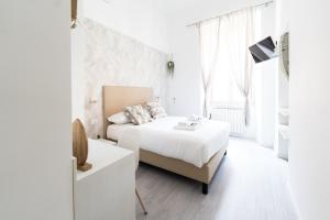 a white bedroom with a bed and a window at White Gioberti Guesthouse in Rome