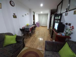 a living room with a couch and a table and a television at Como en casa in Sucre