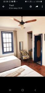 a bedroom with a bed and a ceiling fan at Pousada Casarão da Pedra in Congonhas