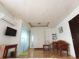 a living room with a table and a chair and a television at Marlene's Hilltop Villa in Cebu City