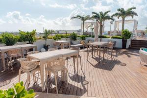 d'une terrasse sur le toit avec des tables et des chaises. dans l'établissement The Reef 28 - Adults Only - All Suites - Optional Gourmet All Inclusive, à Playa del Carmen
