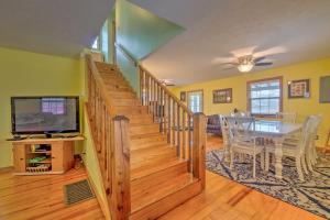 a dining room and living room with a staircase and a table at Lake House with Hot Tub and Fire Pit - 1 Mi to Marina! in Frogue