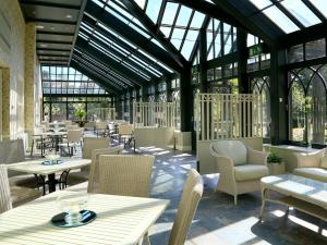 a restaurant with tables and chairs and windows at Gisborough Hall Hotel in Guisborough