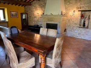 un tavolo e sedie in legno in una stanza con camino di Agriturismo Ca'Verdeselle a Fermignano