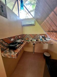 une petite cuisine avec évier et comptoir dans l'établissement Ballena Oasis Homes (Chalets con AC), à Uvita