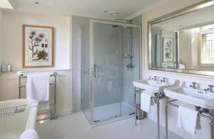 a bathroom with a shower and two sinks and a glass shower stall at Gisborough Hall Hotel in Guisborough