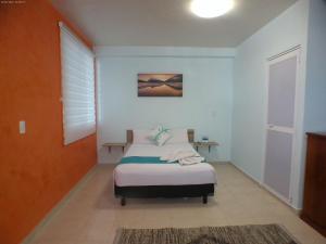 Säng eller sängar i ett rum på Hotel Awazul Bacalar