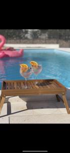 dos copas de vino sentadas en una mesa junto a una piscina en Villa Iva Vodice en Vodice
