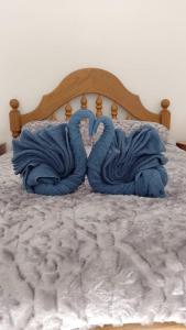 ein Bett mit blauen Handtüchern in Herzform in der Unterkunft El Bambino in Puerto Madryn