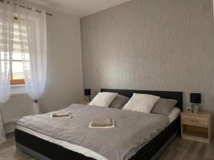 1 dormitorio con 1 cama grande y 2 toallas. en Apartmán Šimon en Cheb