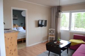 ein Wohnzimmer mit einem Bett und ein Zimmer mit einem Tisch in der Unterkunft Hazel Ridge in Hudiksvall