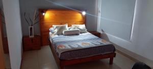 a small bed with a wooden headboard in a room at Eljacaranda_ in Gualeguay +17 photos