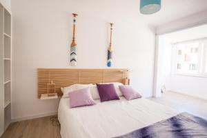 a bedroom with a large bed with purple pillows at Sea, Surf & The City-RENOVATED APRIL 2022 in Costa da Caparica