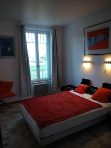 Un dormitorio con una cama con sábanas rojas y una ventana en Maison Haute, en Moux-en-Morvan