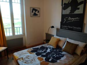 a bedroom with a bed with a blue and white blanket at Maison Haute in Moux-en-Morvan