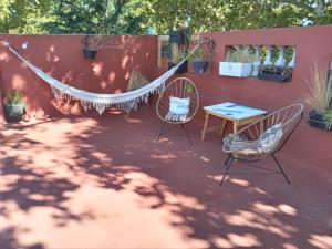 a hammock on a patio with two chairs and a table at Wilson House in Buenos Aires