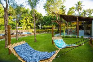 - deux hamacs dans une cour avec une piscine dans l'établissement Villa do Cajueiro - lofts com sala e cozinha, à Imbassaí