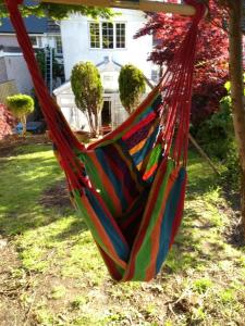 a hammock in a yard with a house at Cosy, dog friendly house on the fringe of the Brecon Beacons in Tredegar
