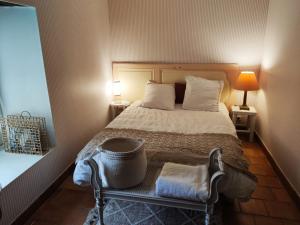 a bedroom with a bed and a chair with two lamps at Le rêve d'Alice in Saint-Puy