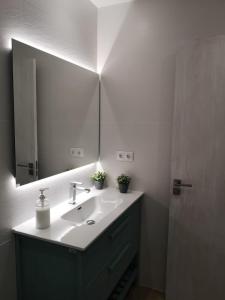 a bathroom with a sink and a large mirror at Casa Serral in Deltebre