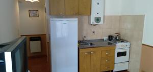 a kitchen with a white stove and a sink at La Colonial Cabañas in Villa Cura Brochero