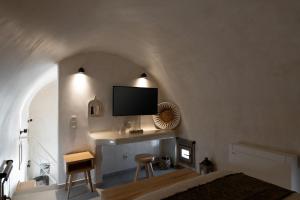 a bedroom with a bed and a tv on the wall at Areos Luxury Suites in Vóthon