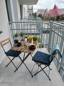 Una mesa y sillas de madera en un balcón. en Apartament z Sauna i Jacuzzi, en Radom