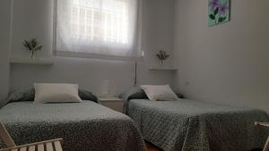 A bed or beds in a room at En Muros, céntrico, amplio, luminoso, vistas al mar