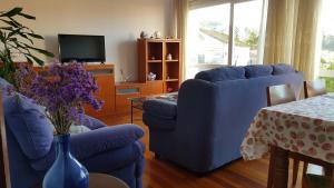 sala de estar con sofá azul y mesa en En Muros, céntrico, amplio, luminoso, vistas al mar, en Muros
