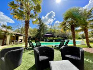 a group of chairs sitting in front of a swimming pool at Les trois cèdres in Saint-ouen-dʼAunis