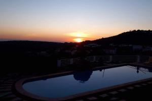 - un coucher de soleil sur la piscine dans l'établissement Monte Velho, à Loulé