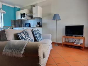 a living room with a couch and a flat screen tv at MirArte in Montemor-o-Novo