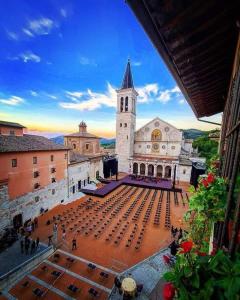 un grand bâtiment avec une église avec une cloche dans l'établissement GRAZIOSO Appartamento, à Spolète