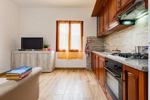a kitchen with wooden floors and a stove top oven at Trilocale Ricky Marina di Campo in Campo nell'Elba