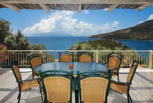 a table and chairs on a patio with a view of the ocean at Anemus in Sivota