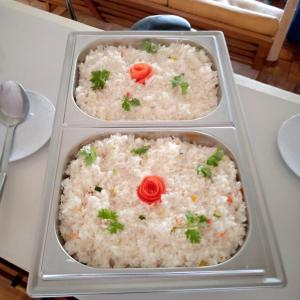 three trays of rice with tomatoes on top on a table at Thayo Place in Nyeri
