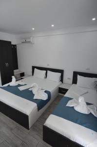 two beds in a room with towels on them at Vila 69 in Costinesti