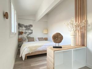 a bedroom with a bed and a table with a fan at La Terrasse sur les Toits in Narbonne
